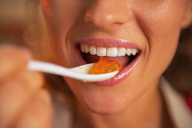 행복한 젊은 여자 클로즈업 대한 먹는 오랑주 jam - gelatin dessert orange fruit marmalade 뉴스 사진 이미지