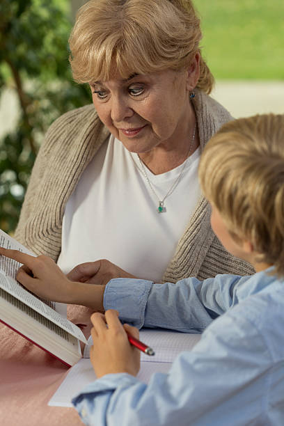 istock Granny and grandchild reading book 525950917