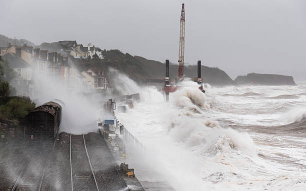 istock Storm at Dawlish with waves breaking over a goods train 525951571