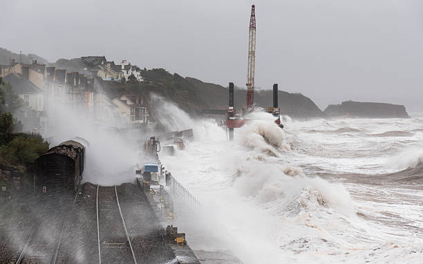 Storm at Dawlish with waves breaking over a goods train stock photo