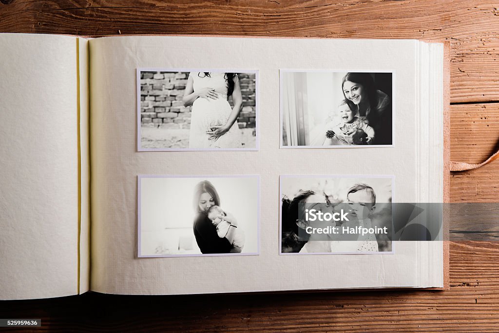 Mothers day composition. Photo album, black-and-white pictures. Mothers day composition. Photo album, black-and-white pictures. Studio shot on wooden background. Photo Album Stock Photo