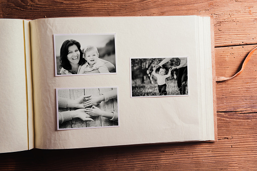 Mothers day composition. Photo album, black-and-white pictures. Studio shot on wooden background.