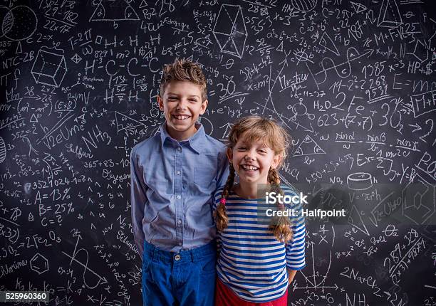 Happy Boy And Girl At School Against Big Blackboard Stock Photo - Download Image Now