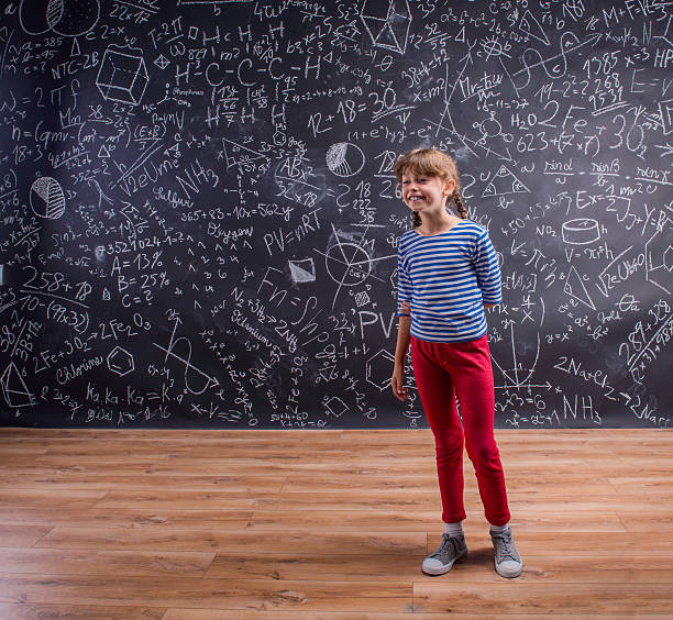 istock Girl  with two braids, big blackboard with mathematical symbols 525960624