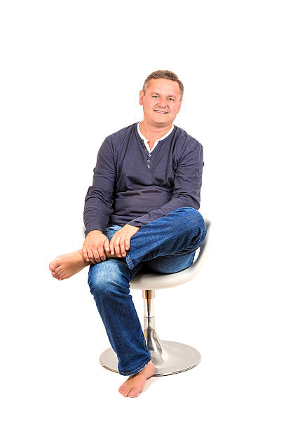 istock Casually dressed middle aged man in chair barefoot 525961134