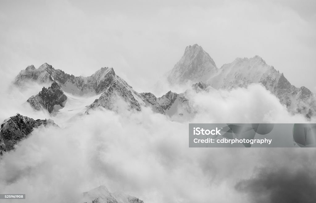 Spring snow showers in the alps Atmospheric clouds linger around the peaks of the Swiss alps after a spring snow storm. Mountain Stock Photo