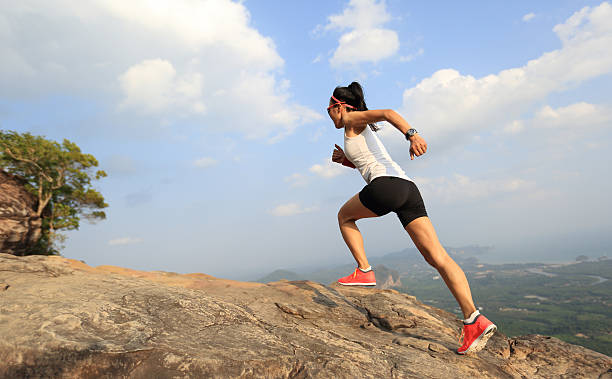 istock young asian woman runner running on mountain peak 525962828