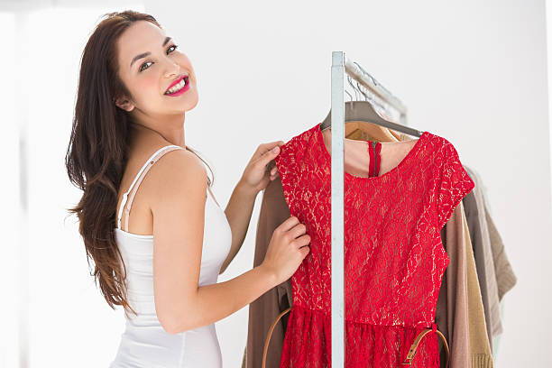 istock Smiling shopping brunette looking at red dress 525963899