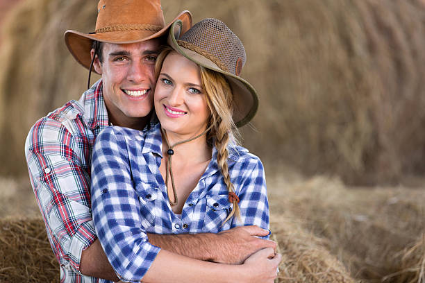 agricoltura giovane coppia abbracciare nel fienile - shirt checked women wild west foto e immagini stock