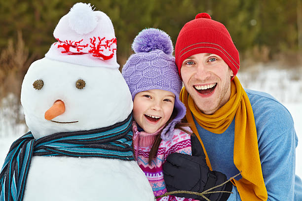 istock Father and daughter with snowman 525964167