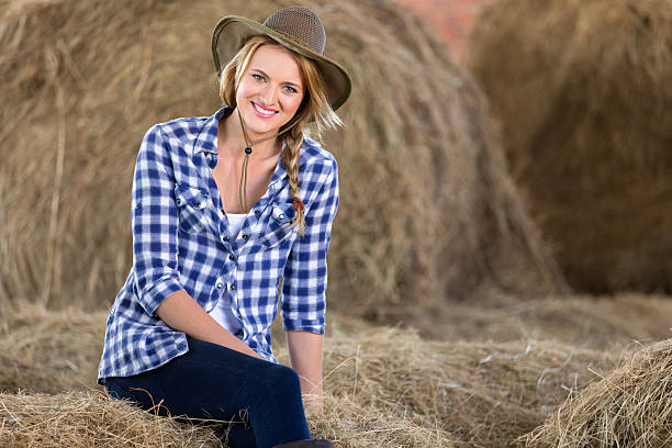 istock cowgirl sitting on hay bales 525964623