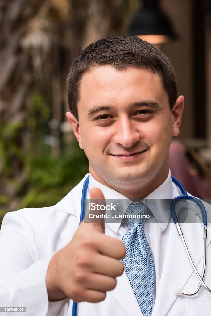 Positive Doctor Smiling Young Doctor posing looking at the camera with his thumbs up 20-29 Years Stock Photo