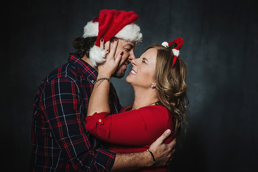 Cute mature Christmas couple in santa hats, happily waiting for christmas.