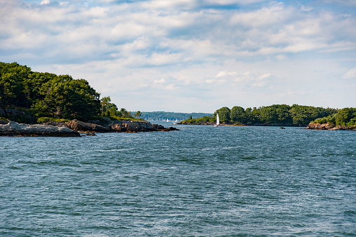 Sailboat wends its way past islands on Casco Bay in Maine