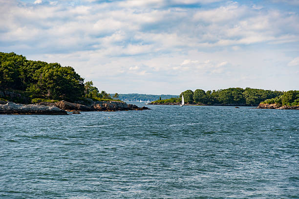 Summer on Casco Bay Sailboat wends its way past islands on Casco Bay in Maine casco bay stock pictures, royalty-free photos & images
