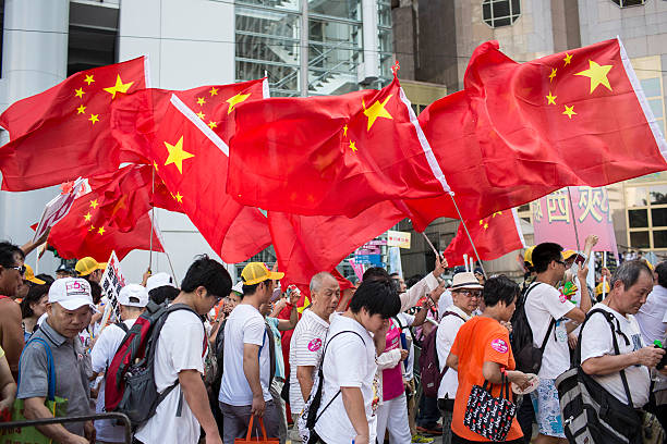 Hong Kong, China – Aug. 17, 2014: Pro-Beijing group activists hold Chinese national flag and march in Central district to oppose \