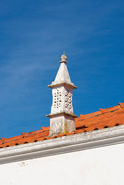 Portugese rooftop chimney Traditional Portugese rooftop chimney against a clear blue sky. alte algarve stock pictures, royalty-free photos & images