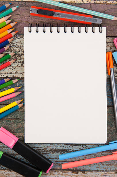 istock Notebook paper and school  tools on vintage wood table 525971218