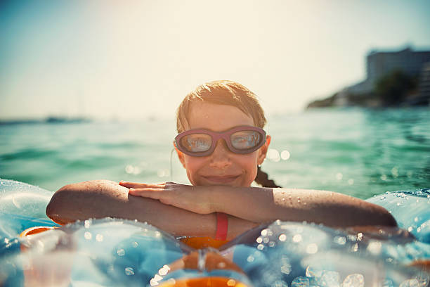 petite fille s'amuser dans la mer - floatation device flash photos et images de collection