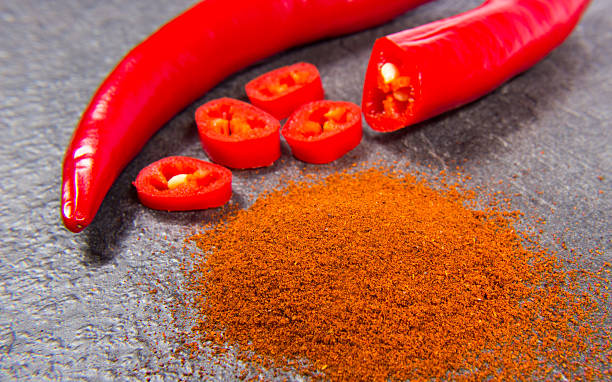 istock Chili peppers and chili powder on a black background 525975726
