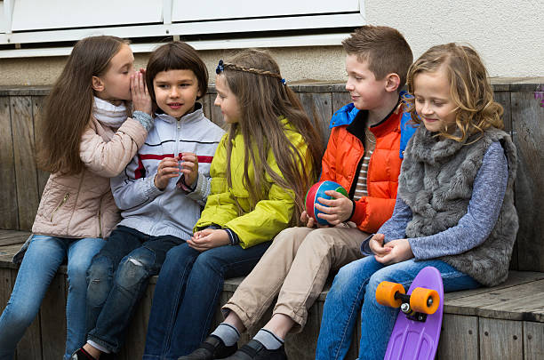 istock Kids whispering in other ears outdoor 525976948