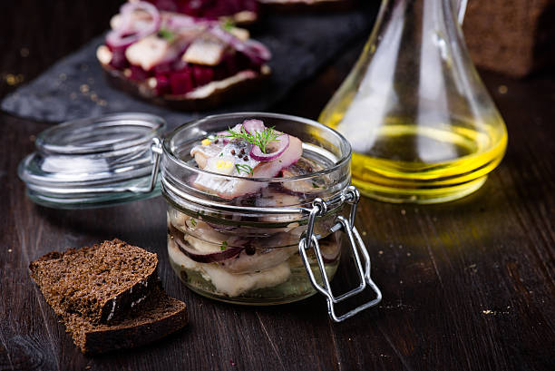 Marinated herring in a jar with herbs and onion Marinated herring in a jar with onion and herbs kipper stock pictures, royalty-free photos & images