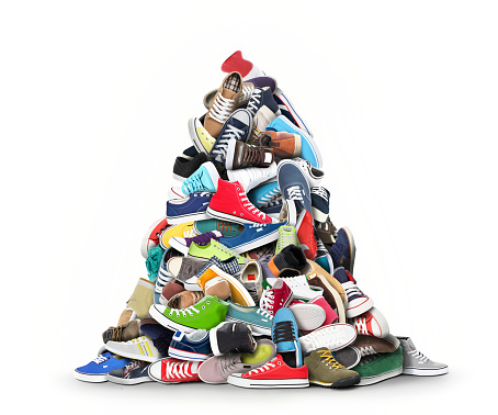 A very large pile of athletic shoes on white background