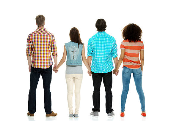 istock Rear view of four people holding hands & standing 525985295