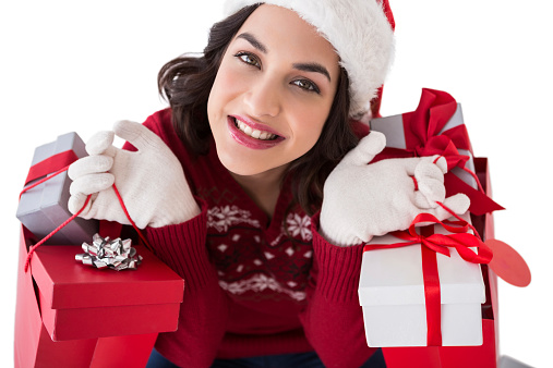 Smiling brunette holding shopping bags full of gifts on white background