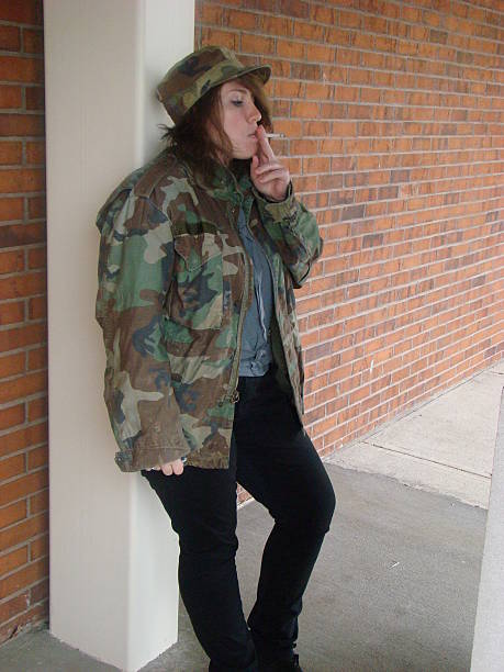 istock Attractive girl in camouflage smoking 525985943