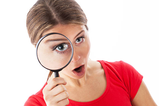 istock Amazed woman holding a magnifying glass 525988663