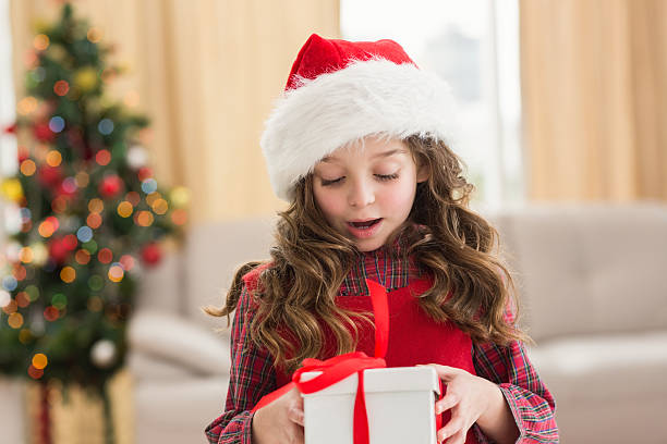 istock Festive little girl opening a gift 525989545