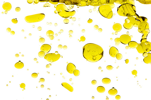 Olive oil drops. Closeup bubbles in water isolated on white