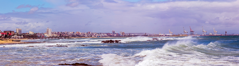 Port Elizabeth panorama, a windy city, rough waves, showing the docks and pier. The Nelson Mandela Stadium can be seen just over the pier.