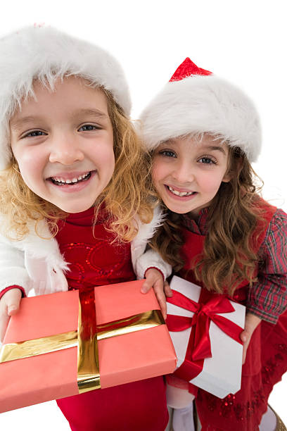 istock Festive little siblings smiling at camera holding gifts 525991331