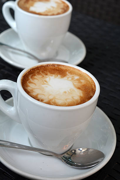 istock Hot Cappuccino In White Cup On The Black Background 525992397