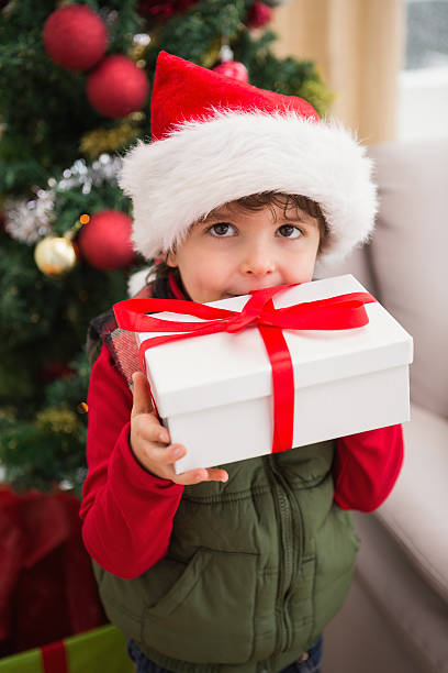 istock Festive little boy smiling at camera with gift 526018107