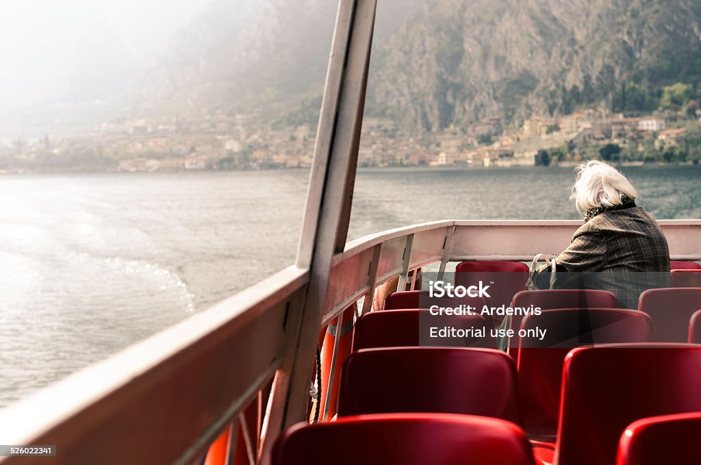 Solitario senior donna Guardando la vista dalla barca, Lago di Garda - Foto stock royalty-free di Acqua