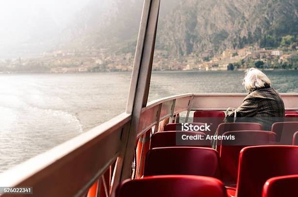 Solitario Senior Donna Guardando La Vista Dalla Barca Lago Di Garda - Fotografie stock e altre immagini di Acqua