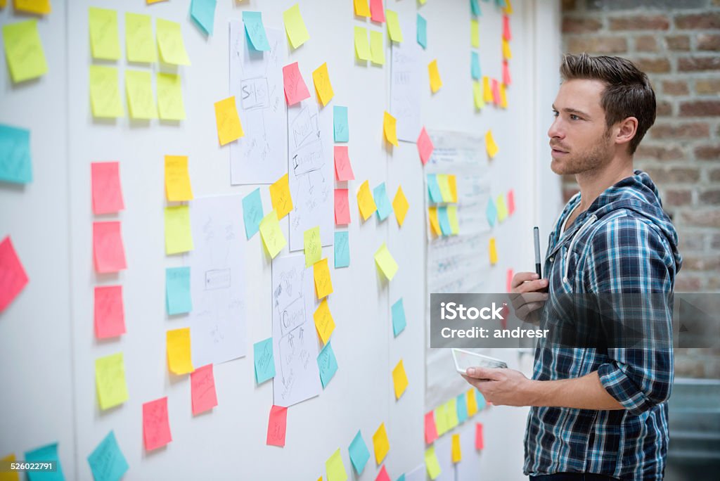 Creative business man Creative business man organizing ideas and posting them Adhesive Note Stock Photo