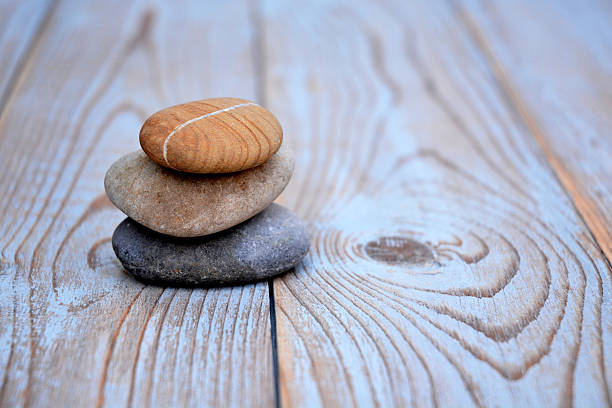 istock Three Zen stones on a wooden background 526023085