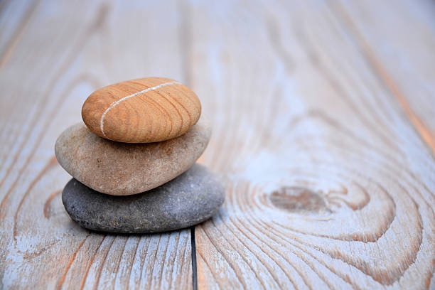 istock Three Zen stones on a wooden background 526024493