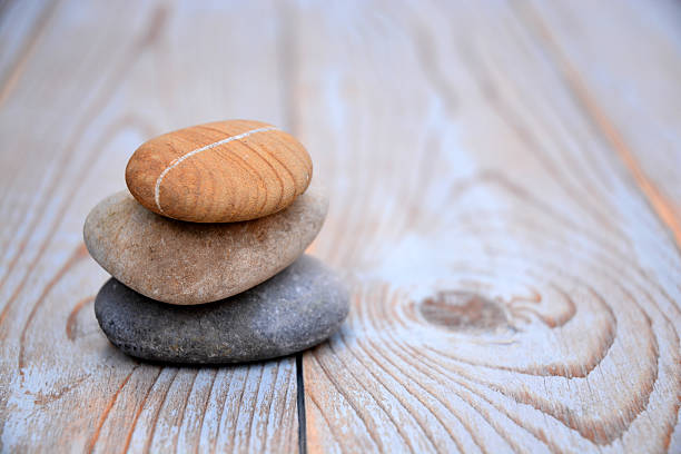 istock Three Zen stones on a wooden background 526024495