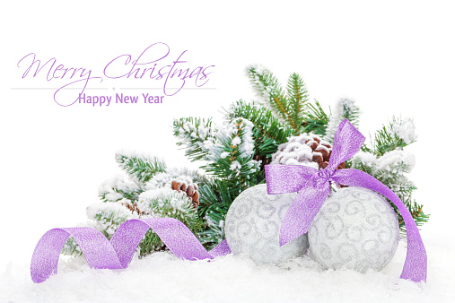 Christmas baubles and purple ribbon with snow fir tree. Isolated on white background with copy space