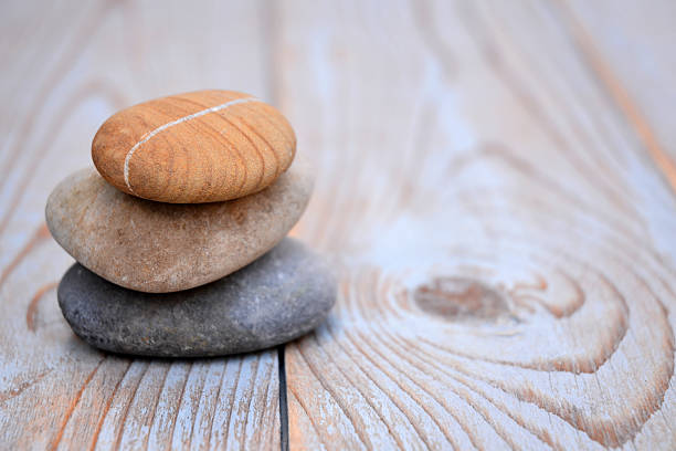 Three Zen stones on a wooden background