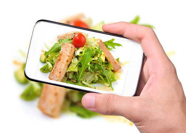 istock Hands taking photo grilled salmon and vegetables with smartphone 526035175