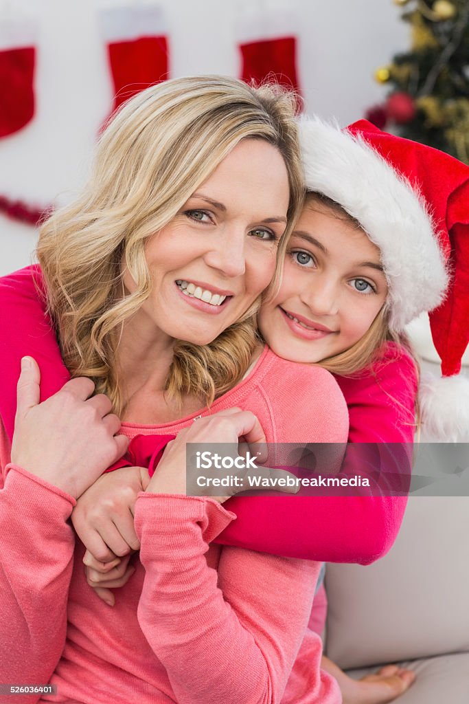 Festive mother and daughter smiling at camera Festive mother and daughter smiling at camera at home in the living room 30-39 Years Stock Photo