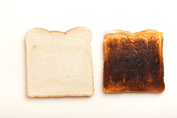 istock Two slices of bread, raw and burnt toast 526037021
