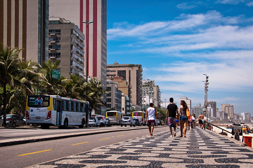 Rio de Janeiro, Brazil - September 24, 2014: People walk on the sidewalk of Avenida Vieira Souto in Ipanema.