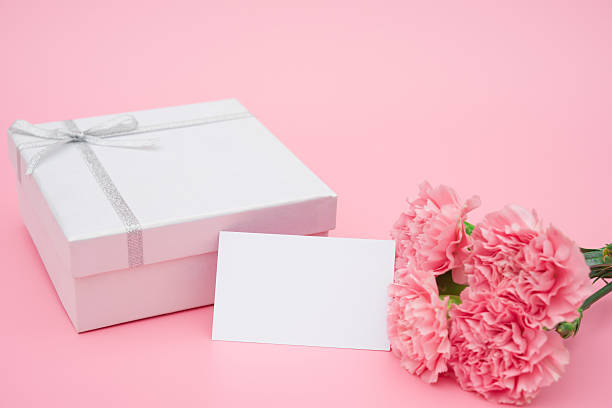 istock present box and pink carnations with a blank card 526039623